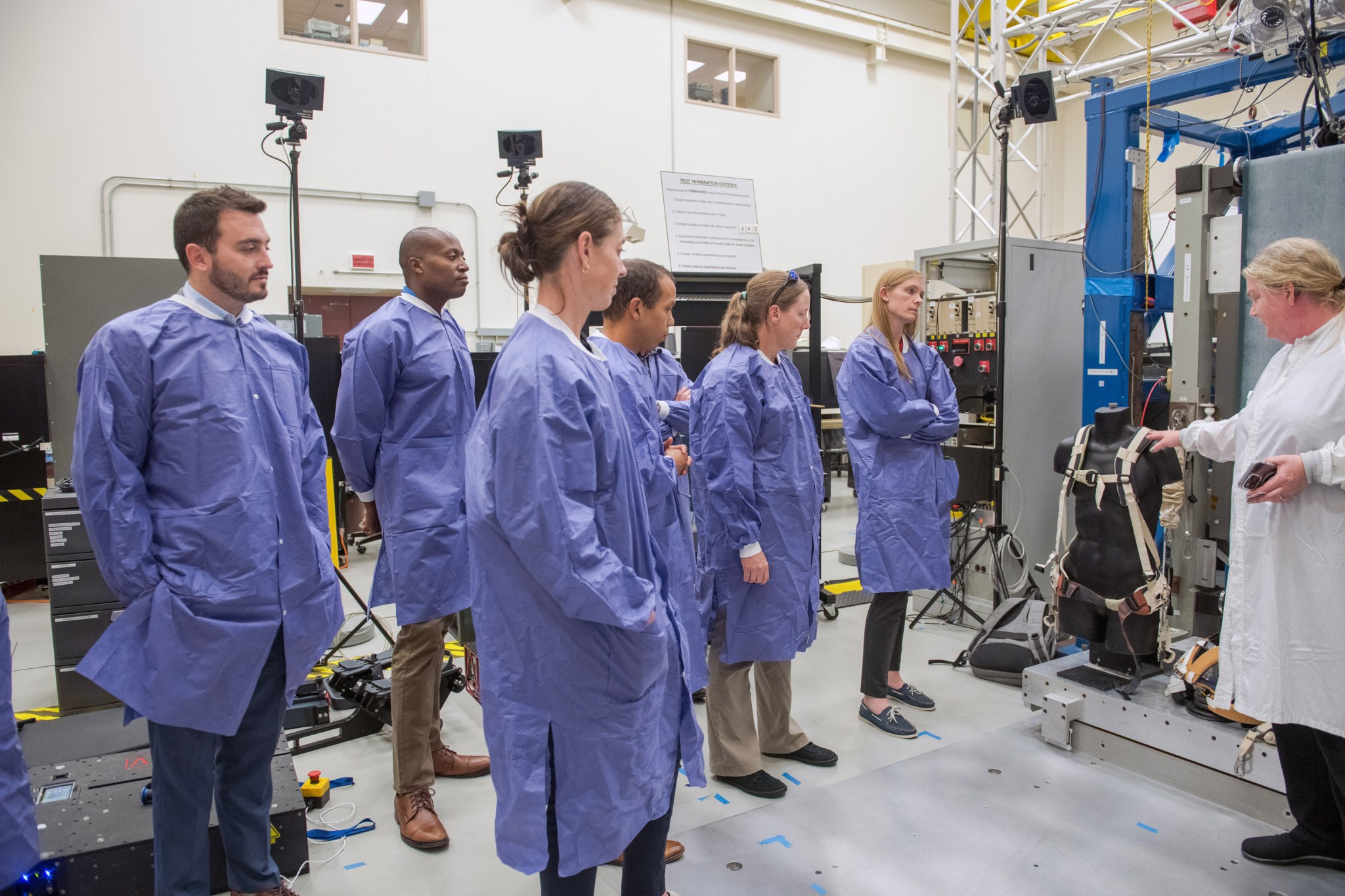 During a tour in the Exercise Countermeasures Lab, NASA Glenn Research Center’s Kelly Gilkey, right, discusses the features of a harness prototype being tested for exercising in space.