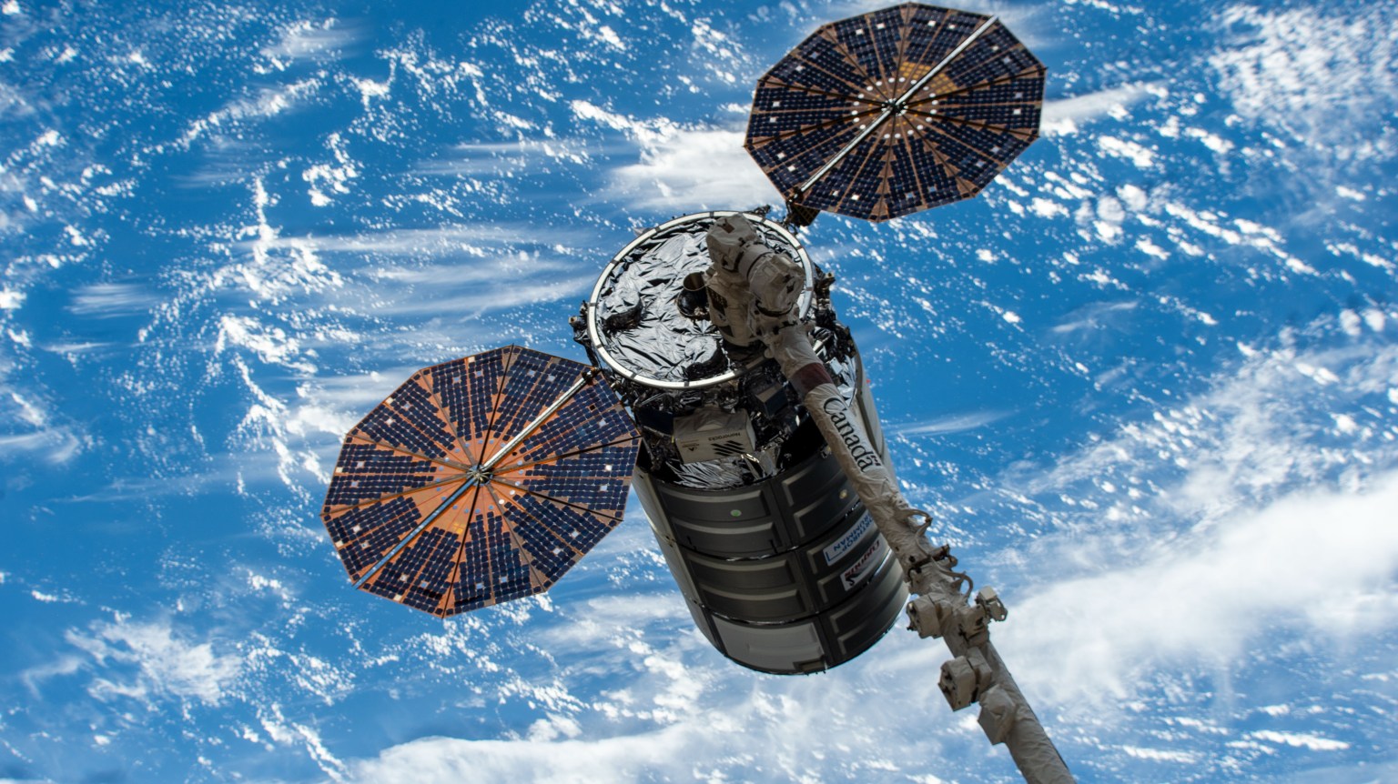 Northrop Grumman's Cygnus space freighter is positioned away from the International Space Station in the grips of the Canadarm2 robotic arm prior to its release ending a four-month stay attached to the orbiting lab's Unity module.