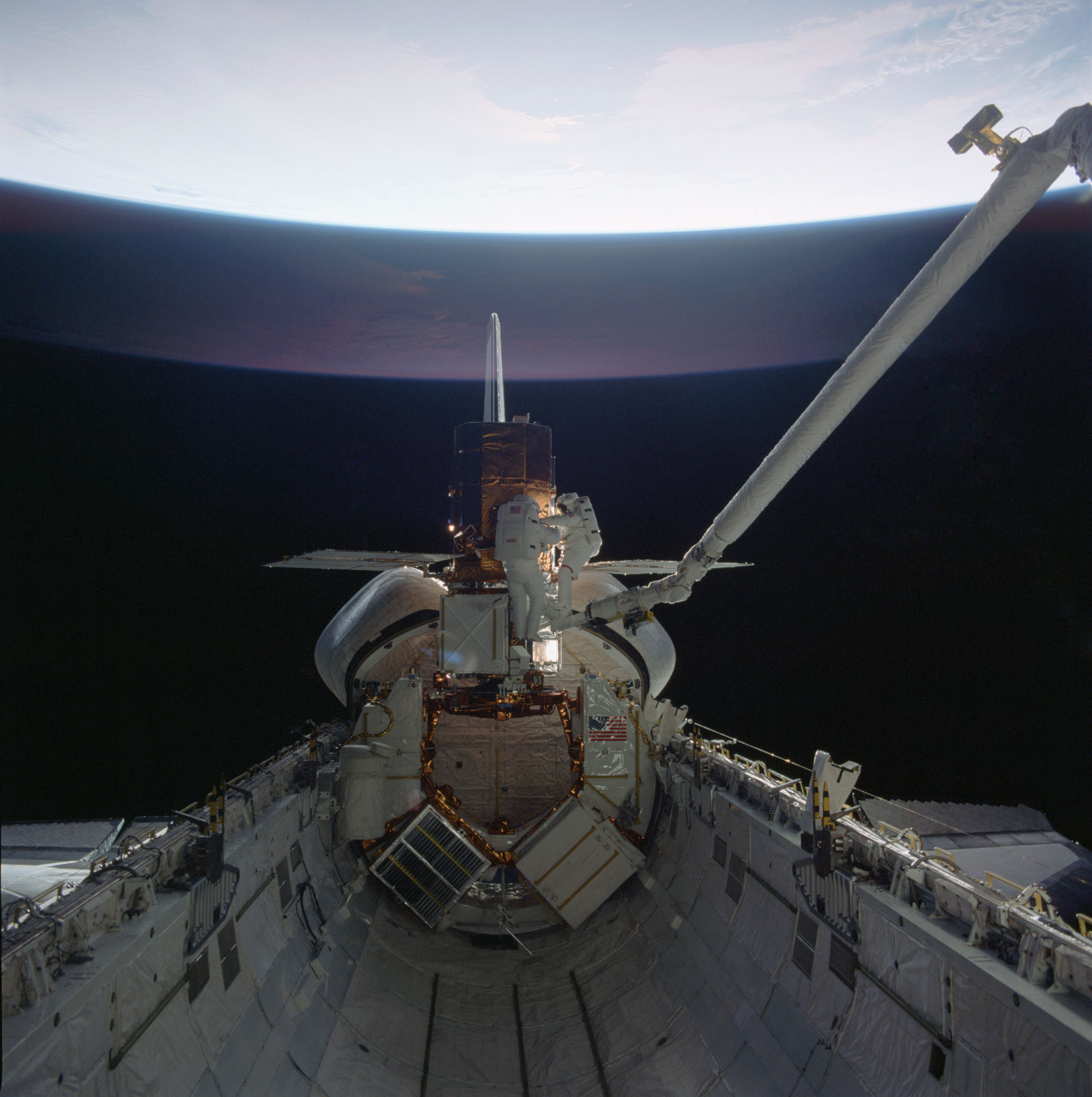 Van Hoften, left, and Nelson replace the main electronics box of one of the satellite’s instruments