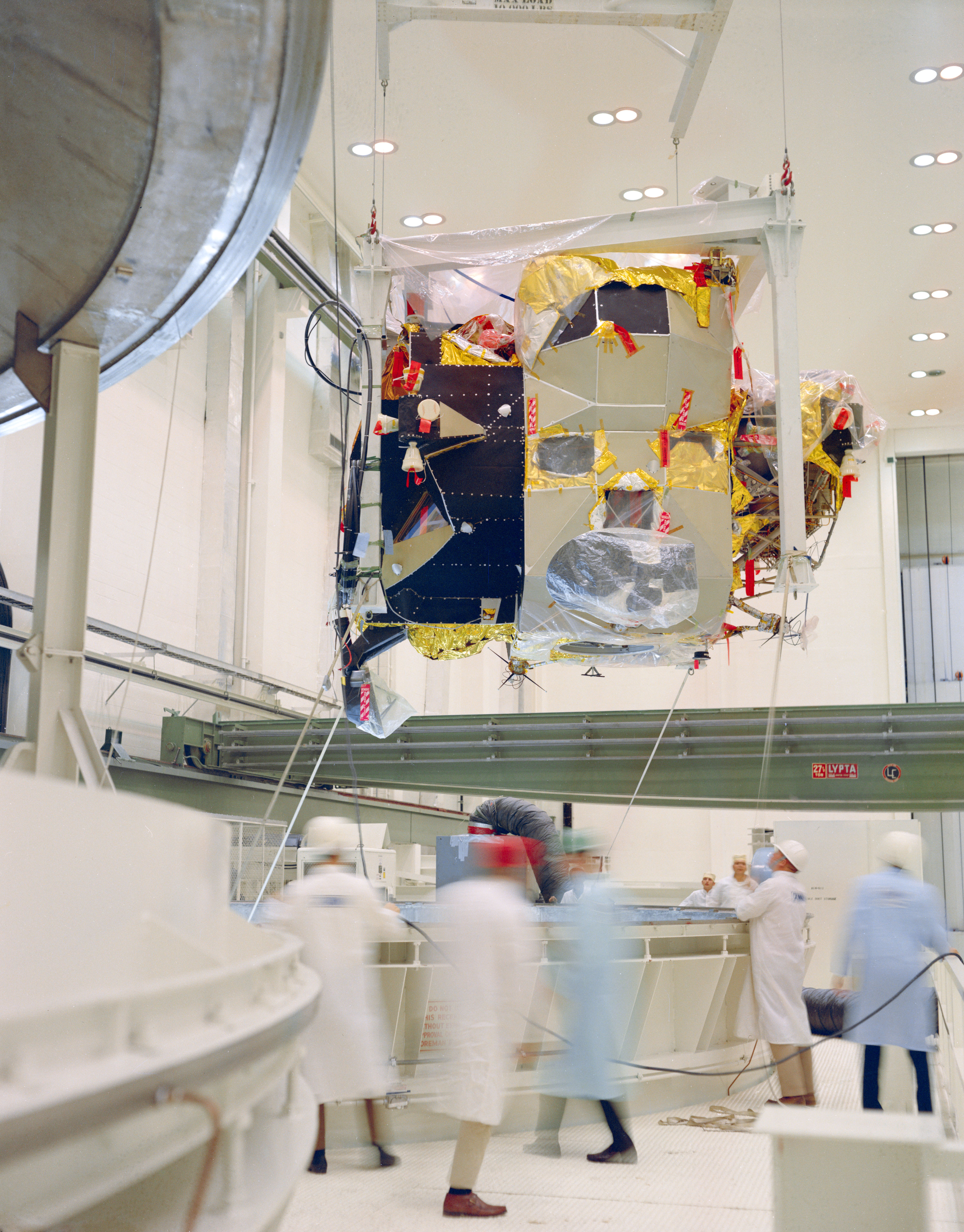 Workers lower the Apollo 12 LM ascent stage onto the Command Module for a docking test