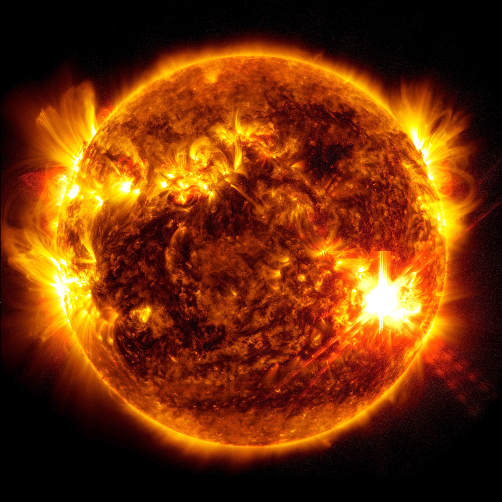 An image of the Sun shows a bright flash in the bottom right side where a solar flare erupts.