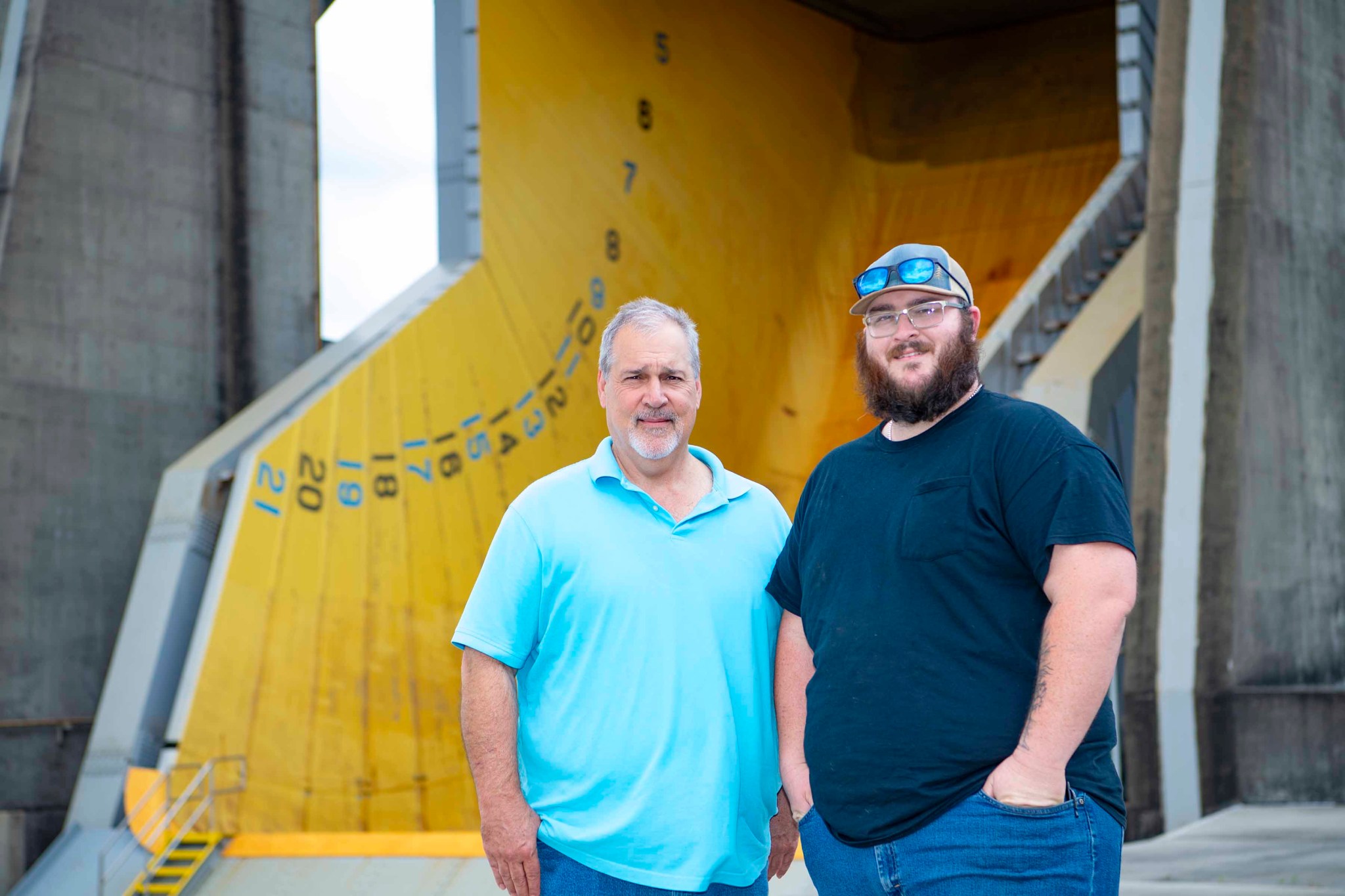 a generational legacy; two men stand at the base of a test stand