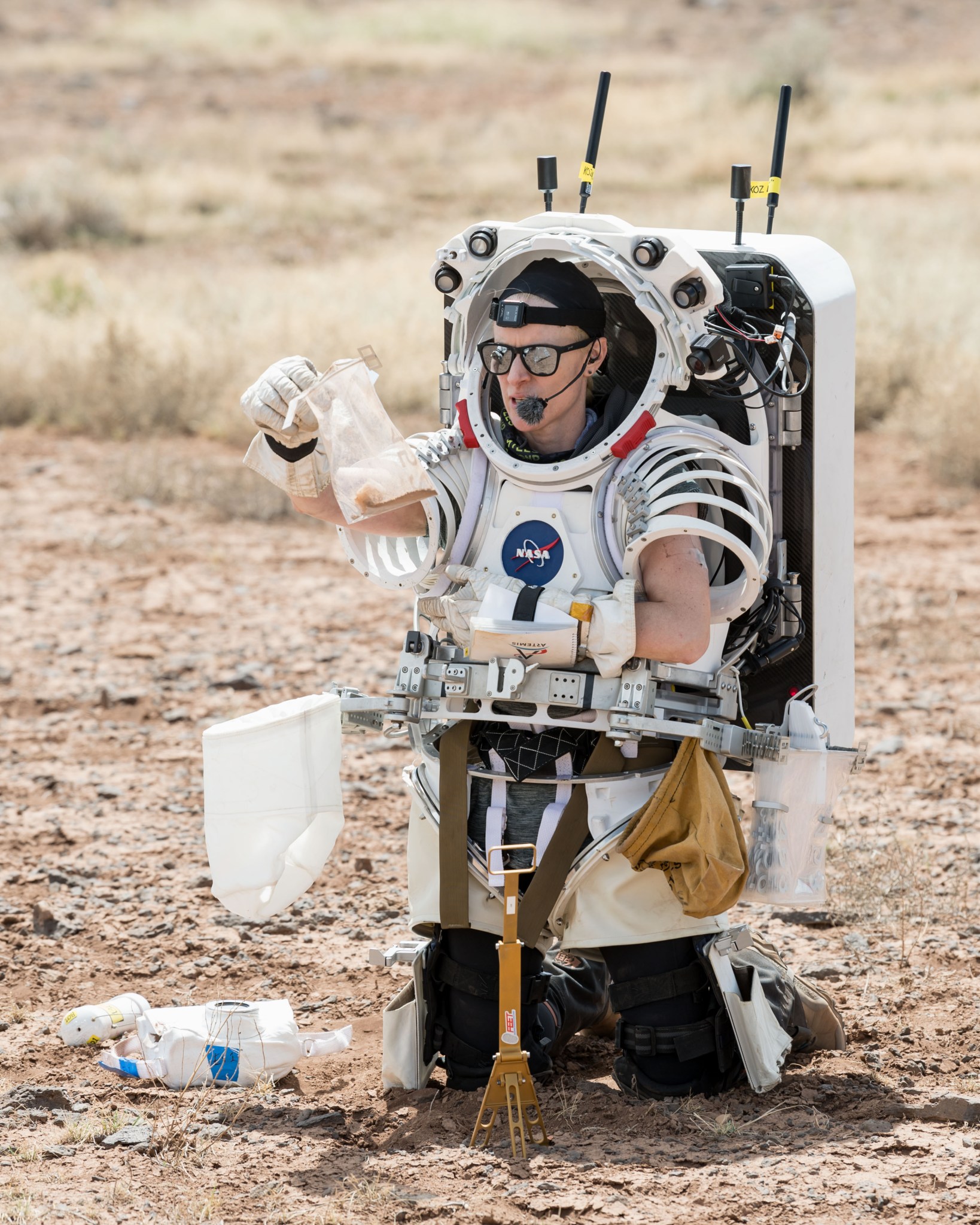 NASA astronaut Kate Rubins observes a geology sample she collected during a simulated moonwalk.