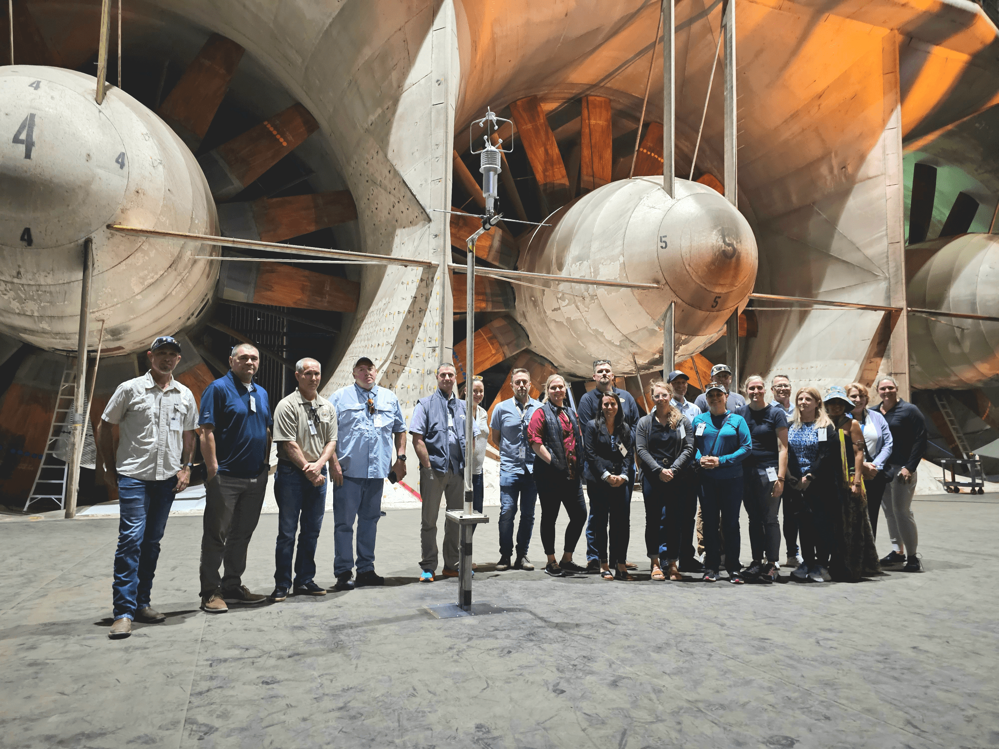 Executive board members from the NWCG stand in front of giant turbines in the National Full Scale Aerodynamic Complex during their visit to Ames Research Center on May 23, 2024.