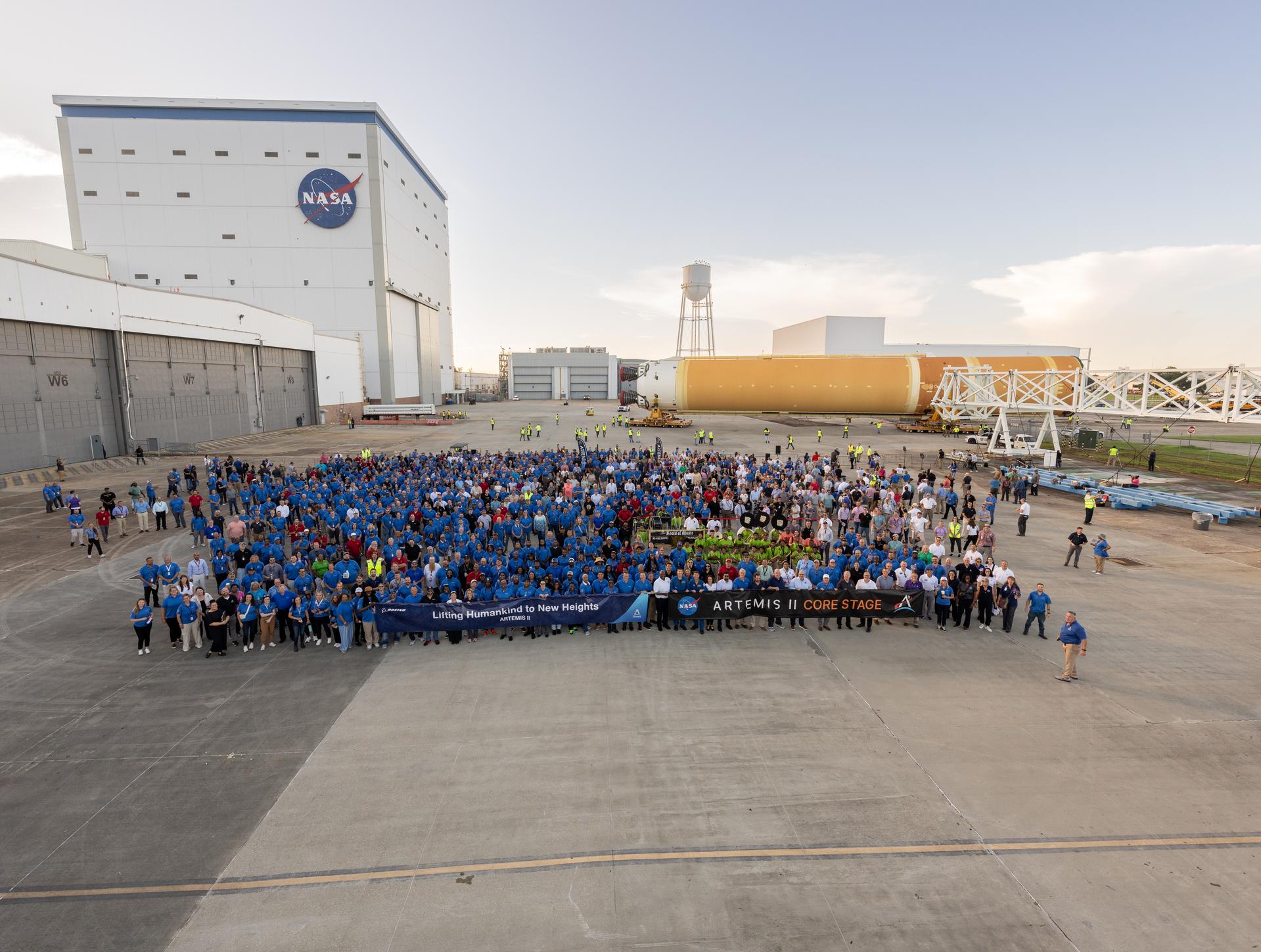 The NASA Michoud Assembly Facility workforce and with other agency team members take a “family photo” with the SLS (Space Launch System) core stage for Artemis II in the background on July 16 at Michoud. The core stage will help launch the first crewed flight of NASA’s SLS rocket for the agency’s Artemis II mission.