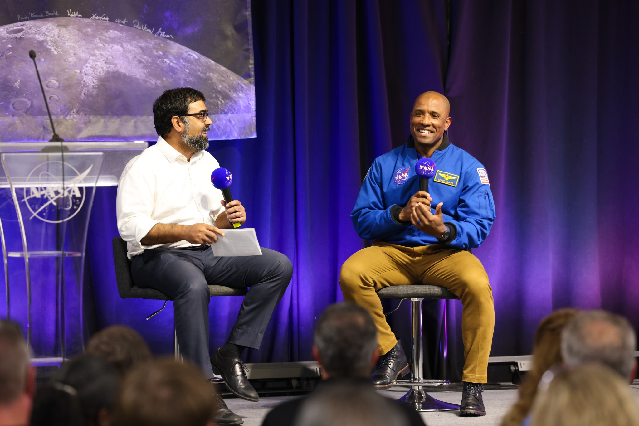 Moon to Mars Program Deputy Associate Administrator Amit Kshatriya, left, and NASA astronaut Victor Glover, right, speak to Michoud Assembly Facility team members on July 15 as part of a Space Flight Awareness event marking Artemis II’s core stage completion. The core stage was rolled out of Michoud’s rocket factory on July 16 for transportation to NASA’s Kennedy Space Center, where it will be integrated with the Orion spacecraft and the remaining components of the SLS (Space Launch System) rocket.