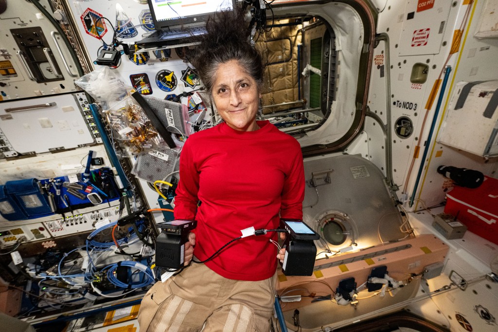 NASA astronaut and Boeing Crew Flight Test Pilot Suni Williams, inside the International Space Station's Unity module, displays portable carbon dioxide monitors recently delivered aboard Northrop Grumman's Cygnus space freighter.