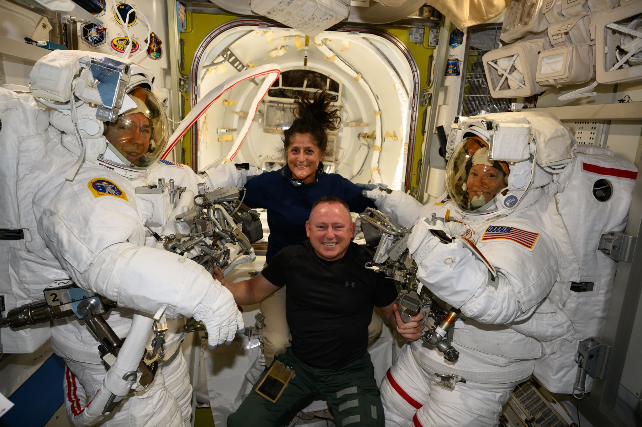 NASA's Boeing Crew Flight Test astronauts Suni Williams and Butch Wilmore (at center) pose with Expedition 71 Flight Engineers (far left) Mike Barratt and Tracy C. Dyson (far right), both NASA astronauts, in their spacesuits aboard the International Space Station's Quest airlock.