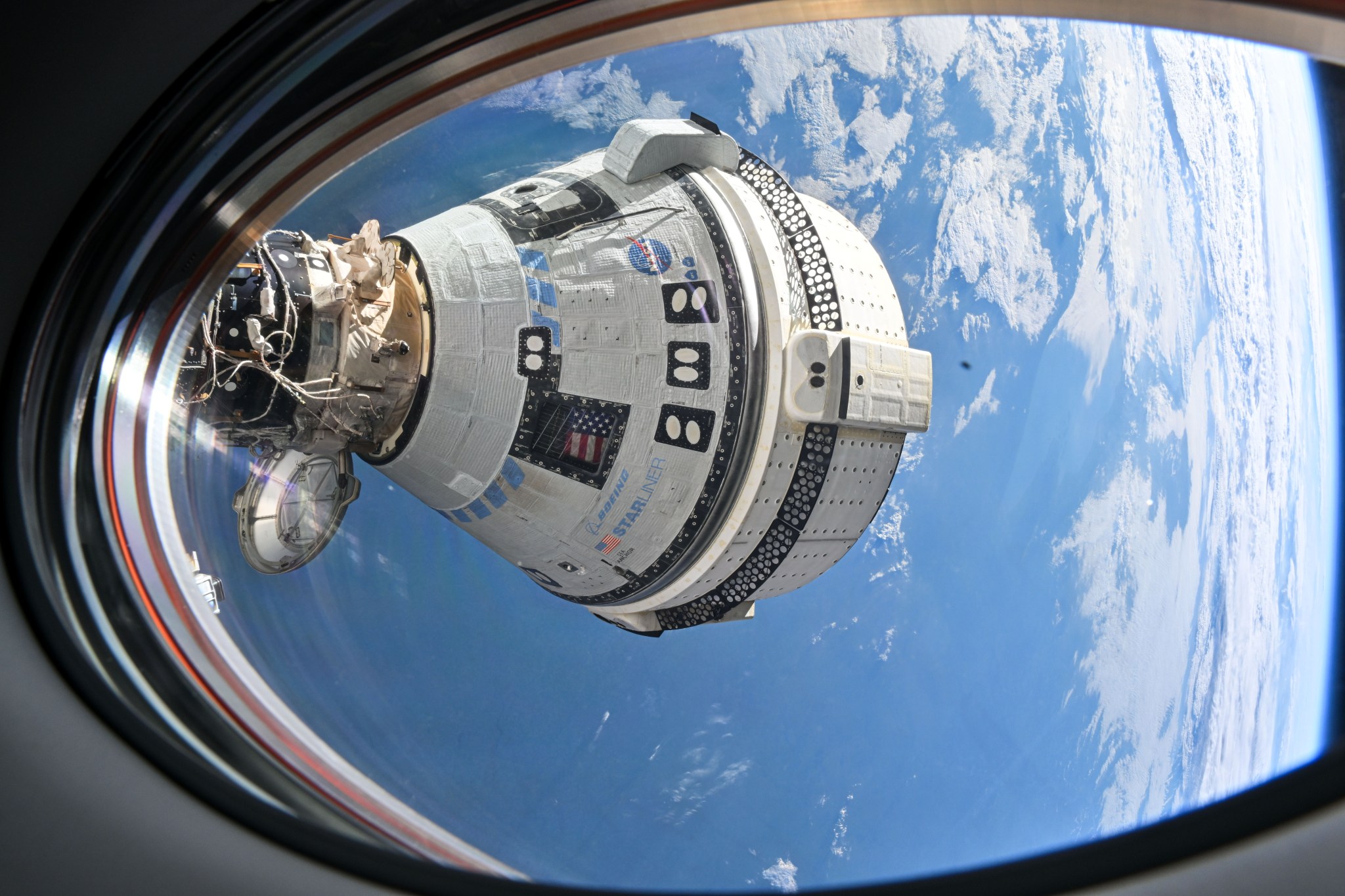 Boeing's Starliner spacecraft that launched NASA's Crew Flight Test astronauts Butch Wilmore and Suni Williams to the International Space Station is pictured docked to the Harmony module's forward port. This view is from a window on the SpaceX Dragon Endeavour spacecraft docked to the port adjacent to the Starliner.