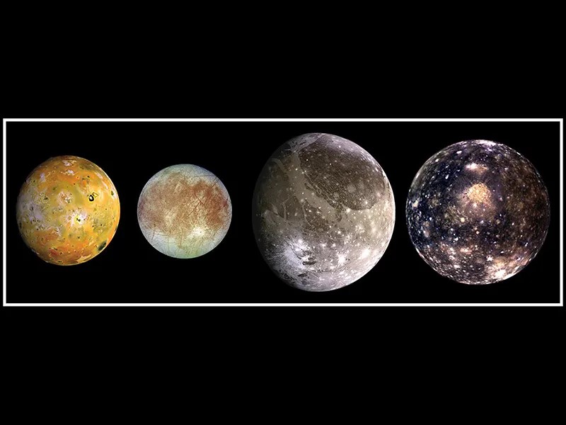 The four largest moons of Jupiter ranging in color from yellowish brown to dark gray.