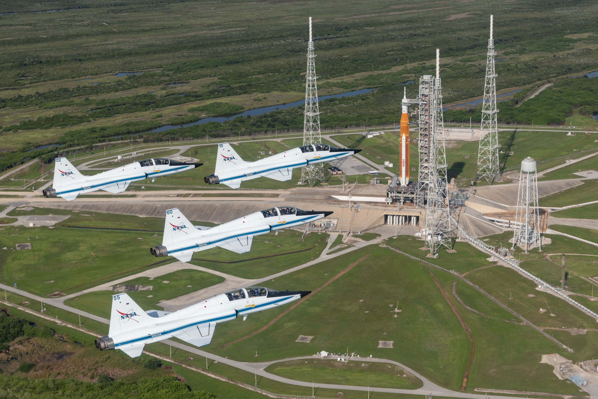 NASA T-38s fly in formation above the Space Launch System rocket on Launch Pad 39B.