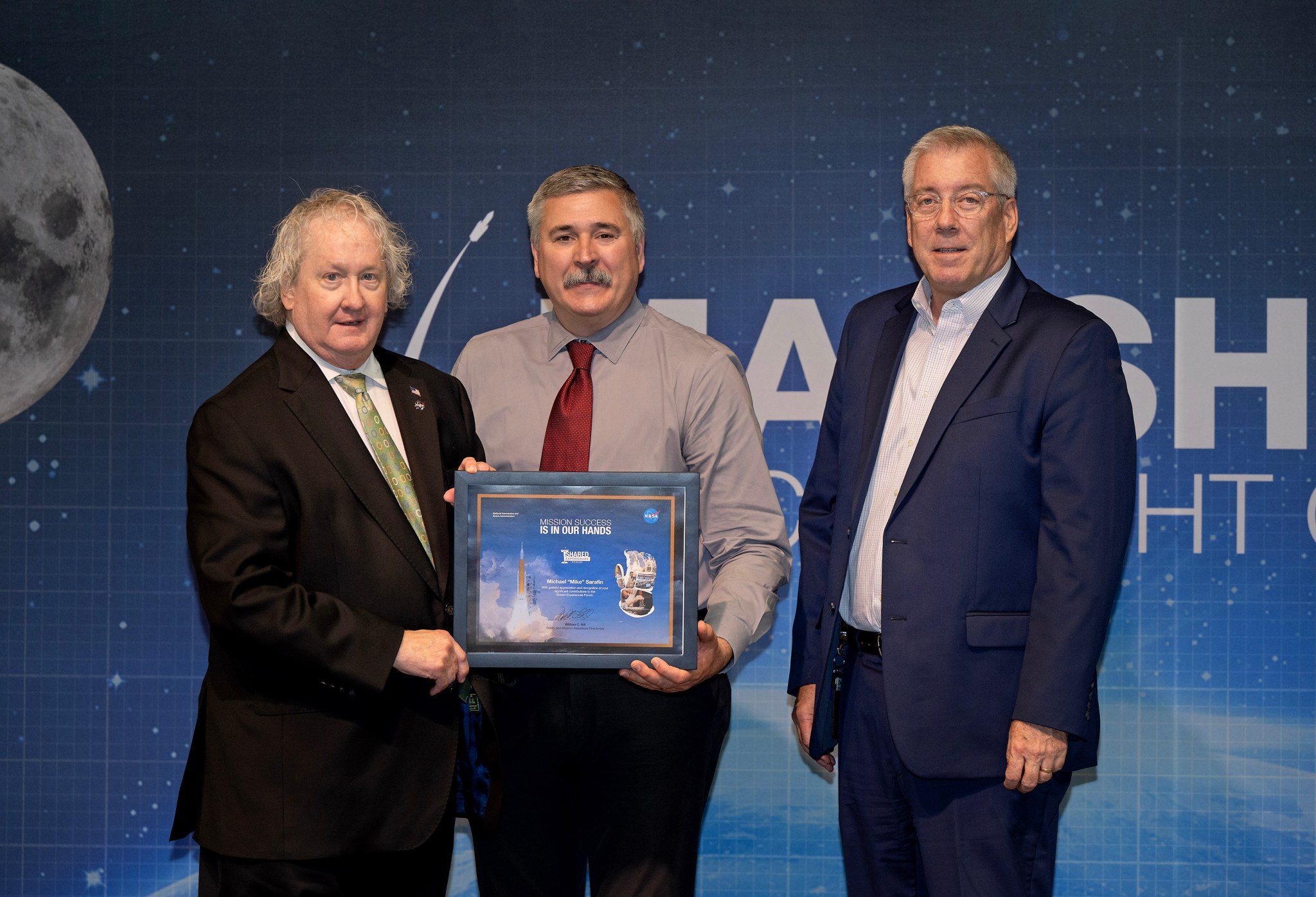 Bill Hill, left, director of Safety and Mission Assurance at Marshall, presents Sarafin with a certificate of appreciation following the Shared Experiences Forum. At right is Jeff Haars, Jacobs vice president and program manager for Jacobs Space Exploration Group.