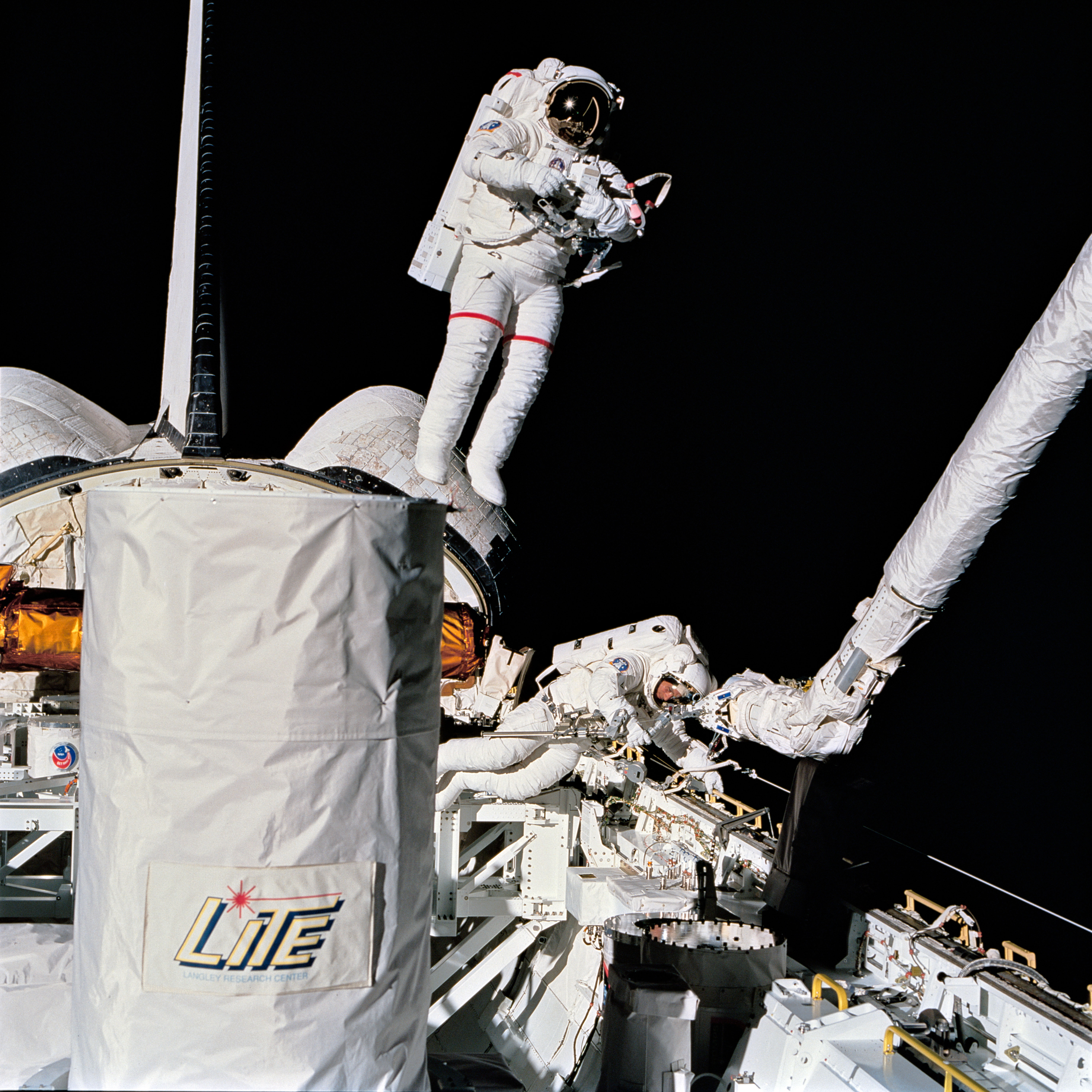 Lee, left, tests the SAFER while Meade works on other tasks in the payload bay