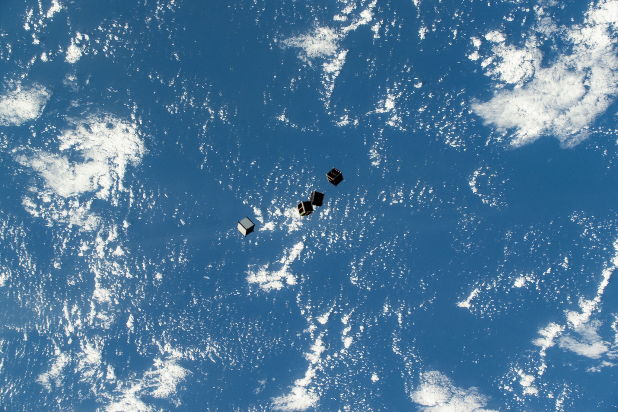 Tiny satellites, also known as CubeSats, are pictured after being deployed into Earth orbit from a small satellite orbital deployer on the outside of the International Space Station's Kibo laboratory module.