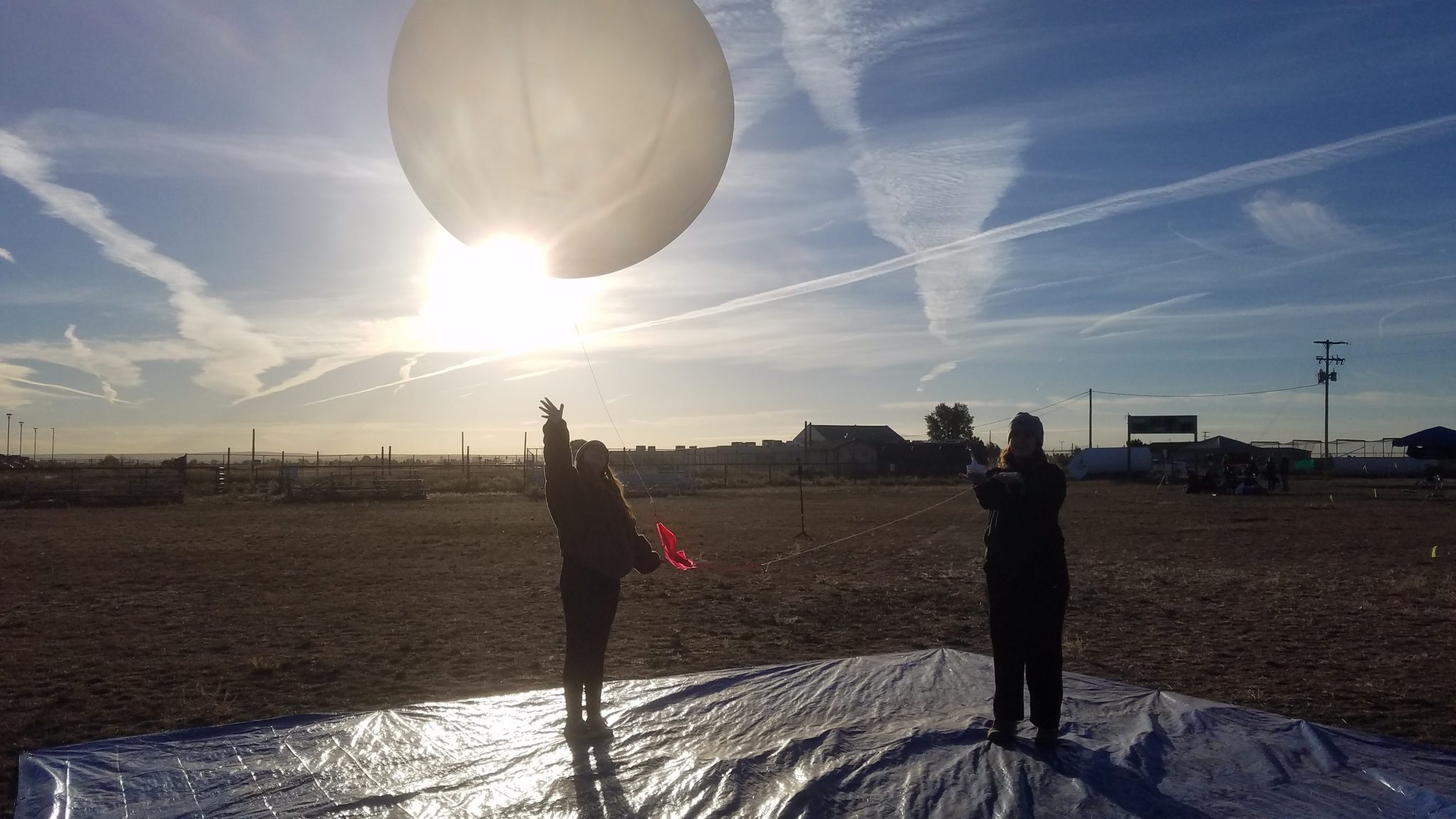 Plymouth State University students Sarah Brigandi, left, and Sammantha Boulay release a weather balloon from Moriarty, New Mexico, to collect atmospheric data on Oct. 14, 2023.