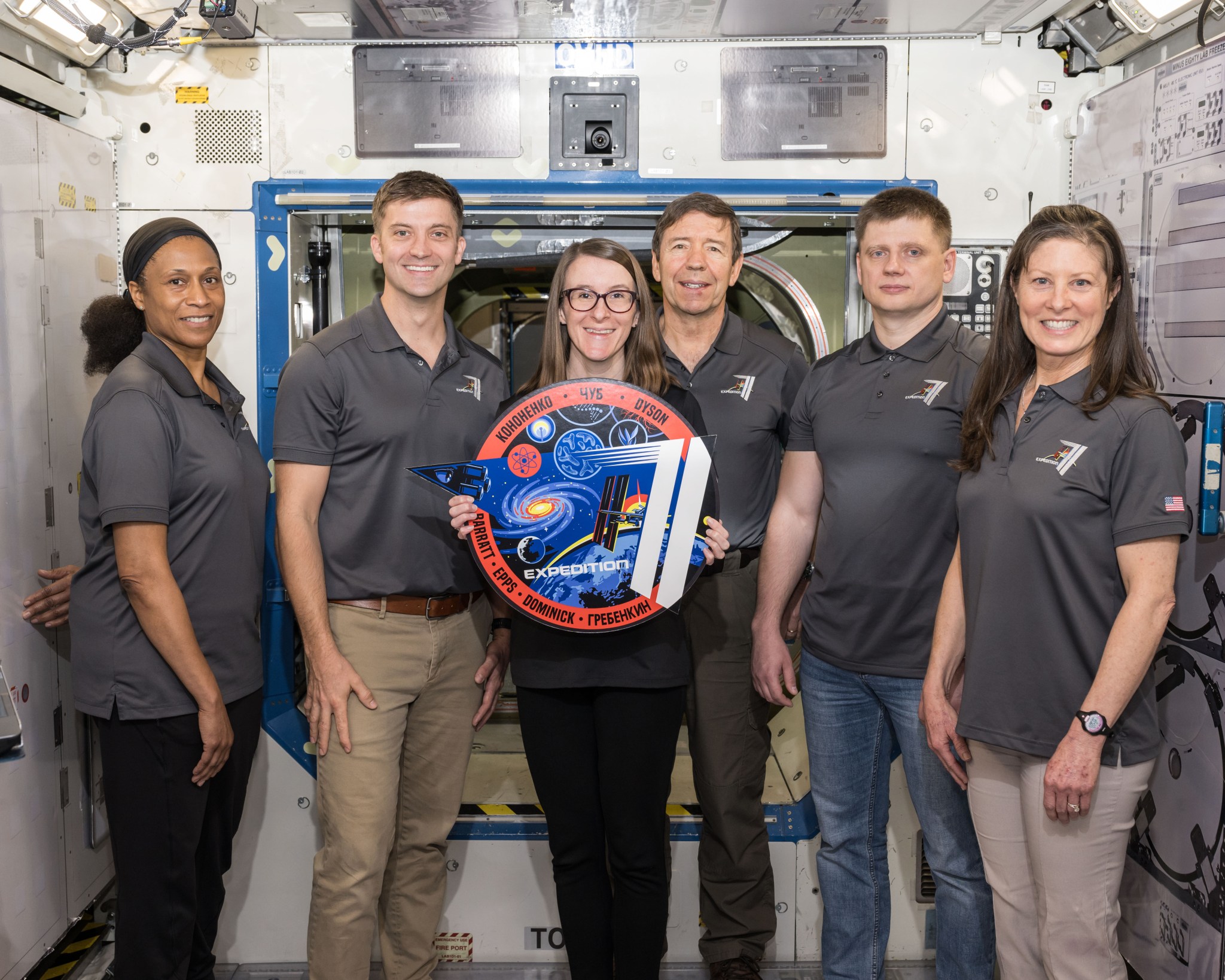 A member of the NASA astronaut training team poses for a picture with members of the ISS Expedition 71 crew.