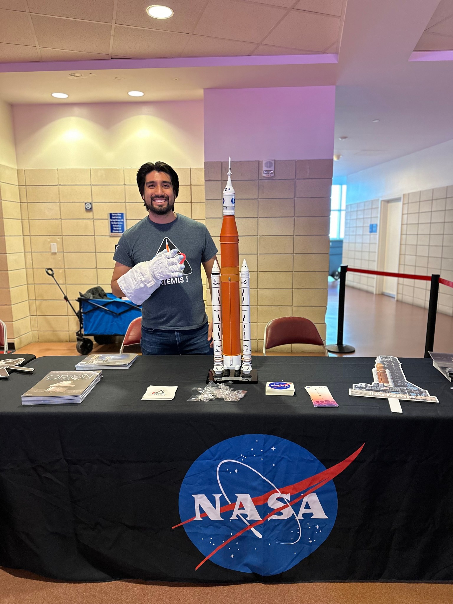 A NASA employee staffs an agency exhibit table at a community engagement event.