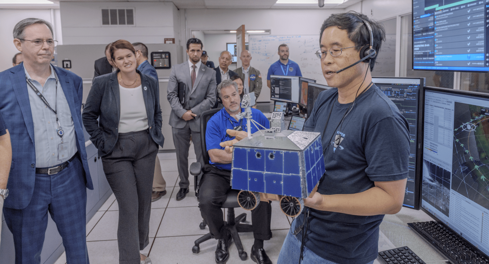 Terry Fong, right, explains the operation of the Volatiles Investigating Polar Exploration Rover (VIPER)