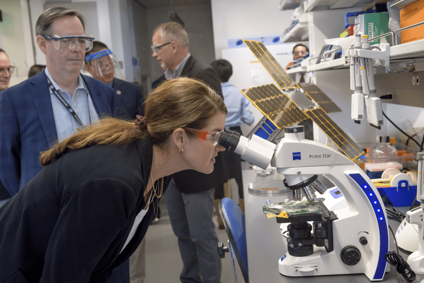 Deputy Associate Administrator Casey Swails examines a sample of algae through a microscope in the Space Biosciences Research Laboratory, N288.