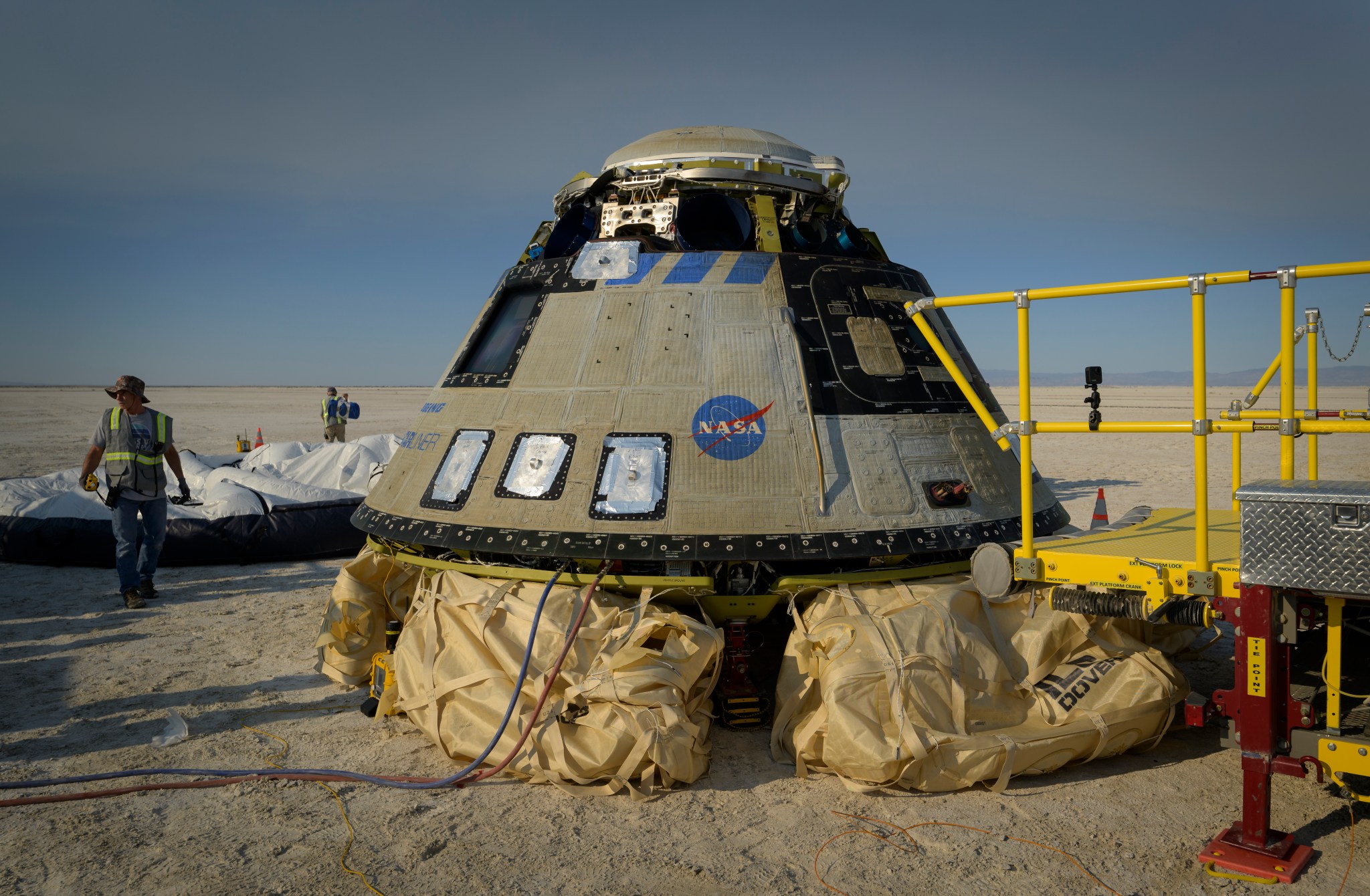 NASA and Boeing teams work around Boeing’s Starliner spacecraft after it landed at White Sands Missile Range’s Space Harbor, May 25, 2022, in New Mexico for the company’s Boeing’s Orbital Flight Test-2 (Credits: NASA/Bill Ingalls).