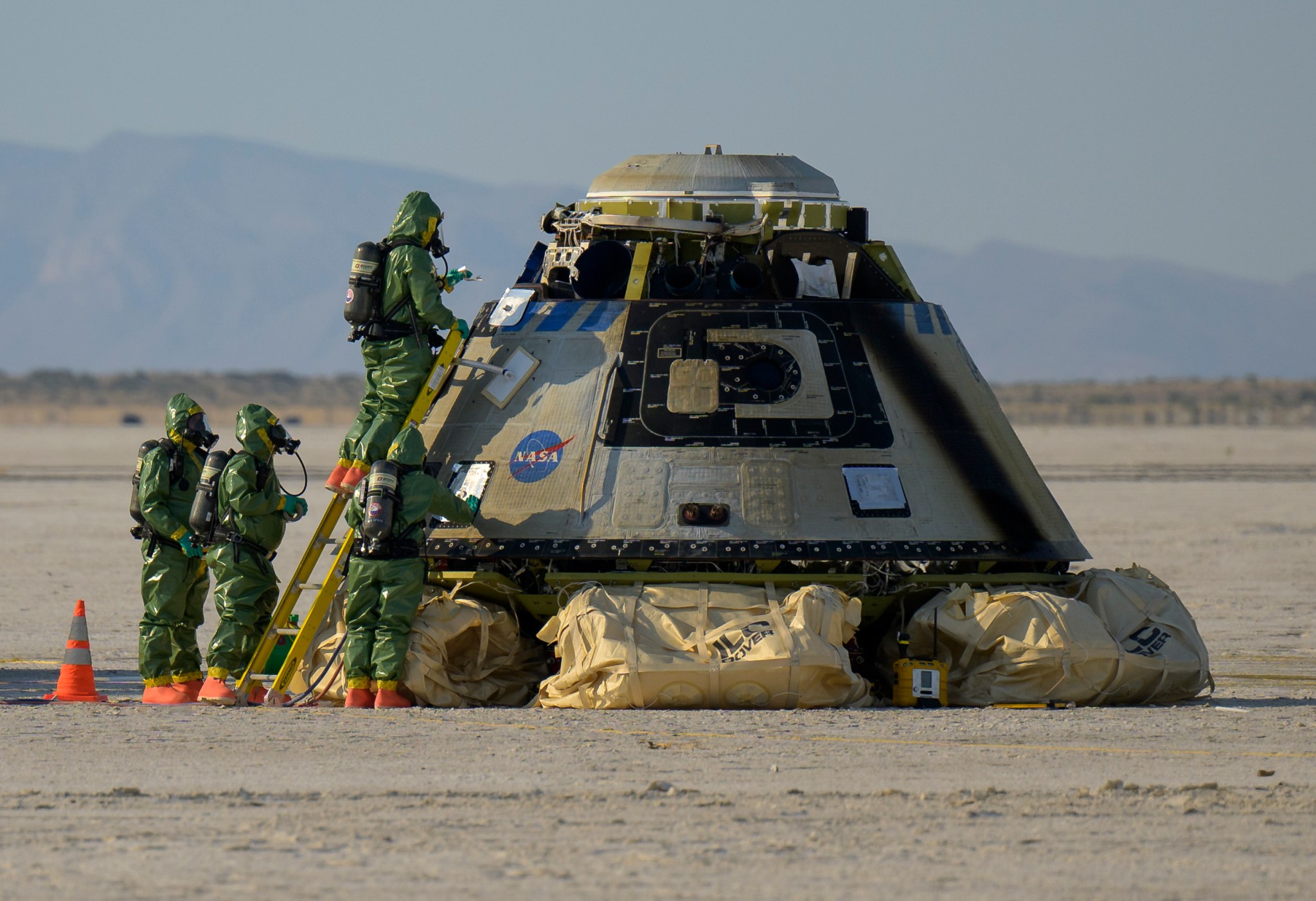 Hazmat teams work around Boeing’s Starliner spacecraft after it landed at White Sands Missile Range’s Space Harbor, May 25, 2022, in New Mexico for the company’s Orbital Flight Test-2 (Credits: NASA/Bill Ingalls).