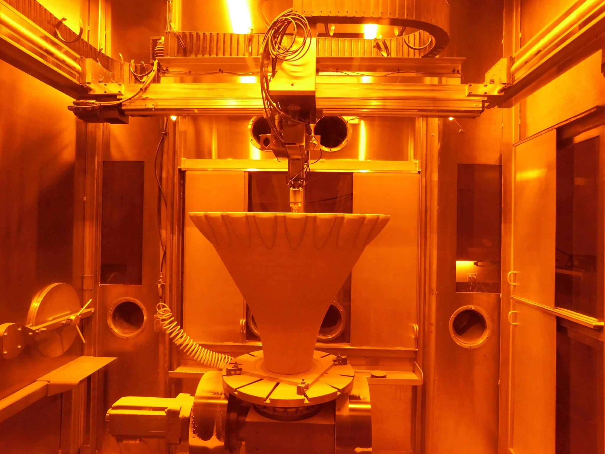 A 3D printer at RPM Innovations’ facility additively manufactures a funnel-shaped aerospike rocket engine nozzle