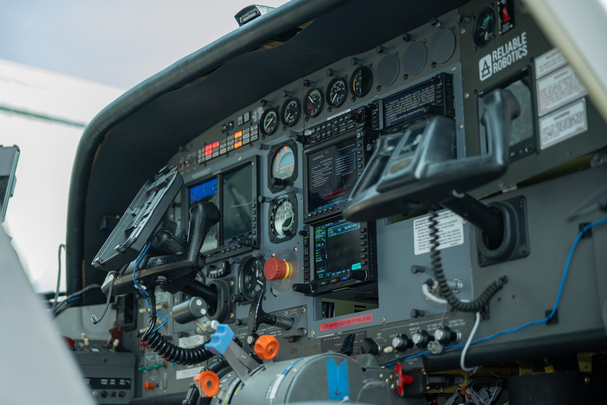 A close up image of a cockpit of a Cessna 208, showing various controls and mechanics.